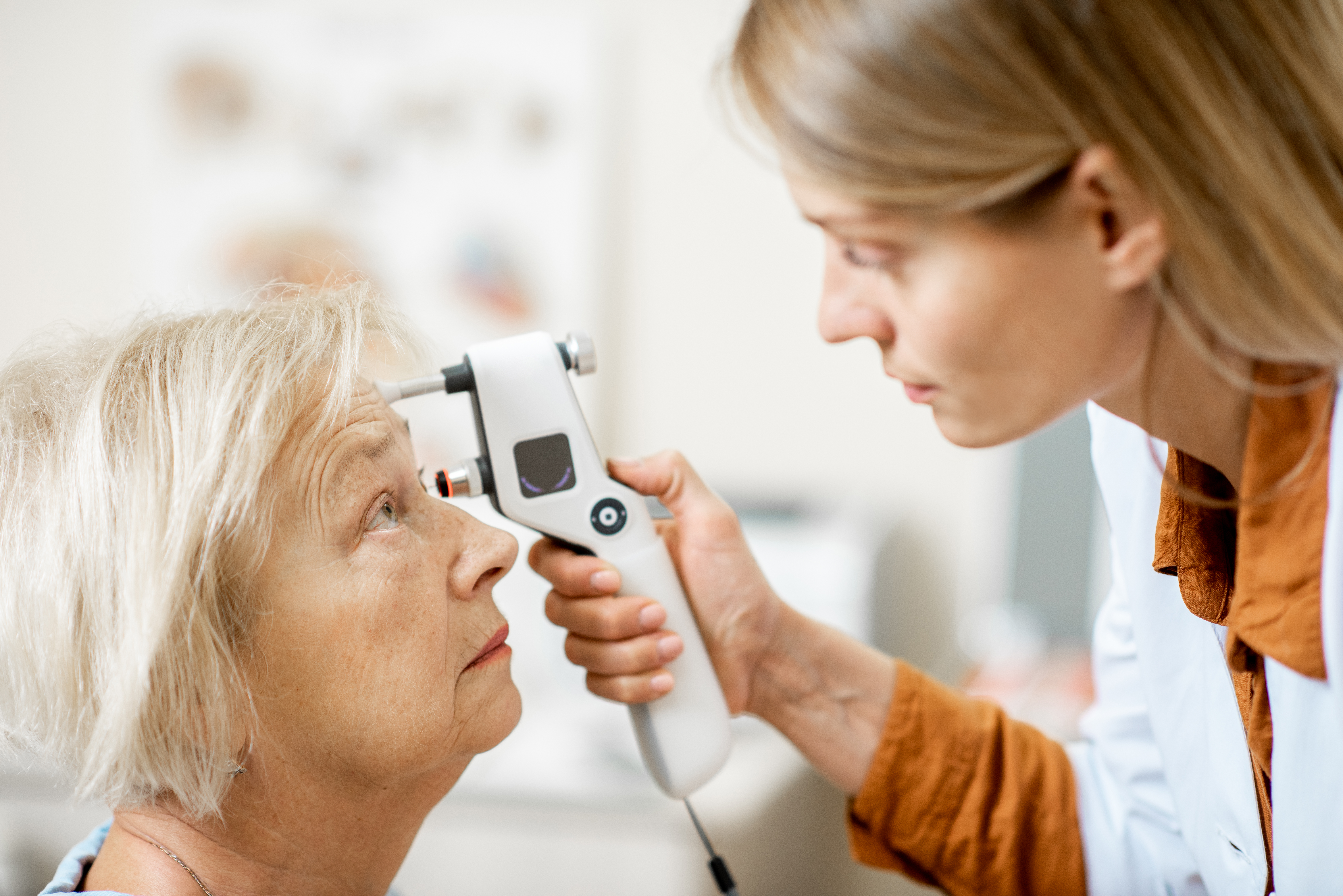 Ophthalmologist measuring eye pressure to a senior woman